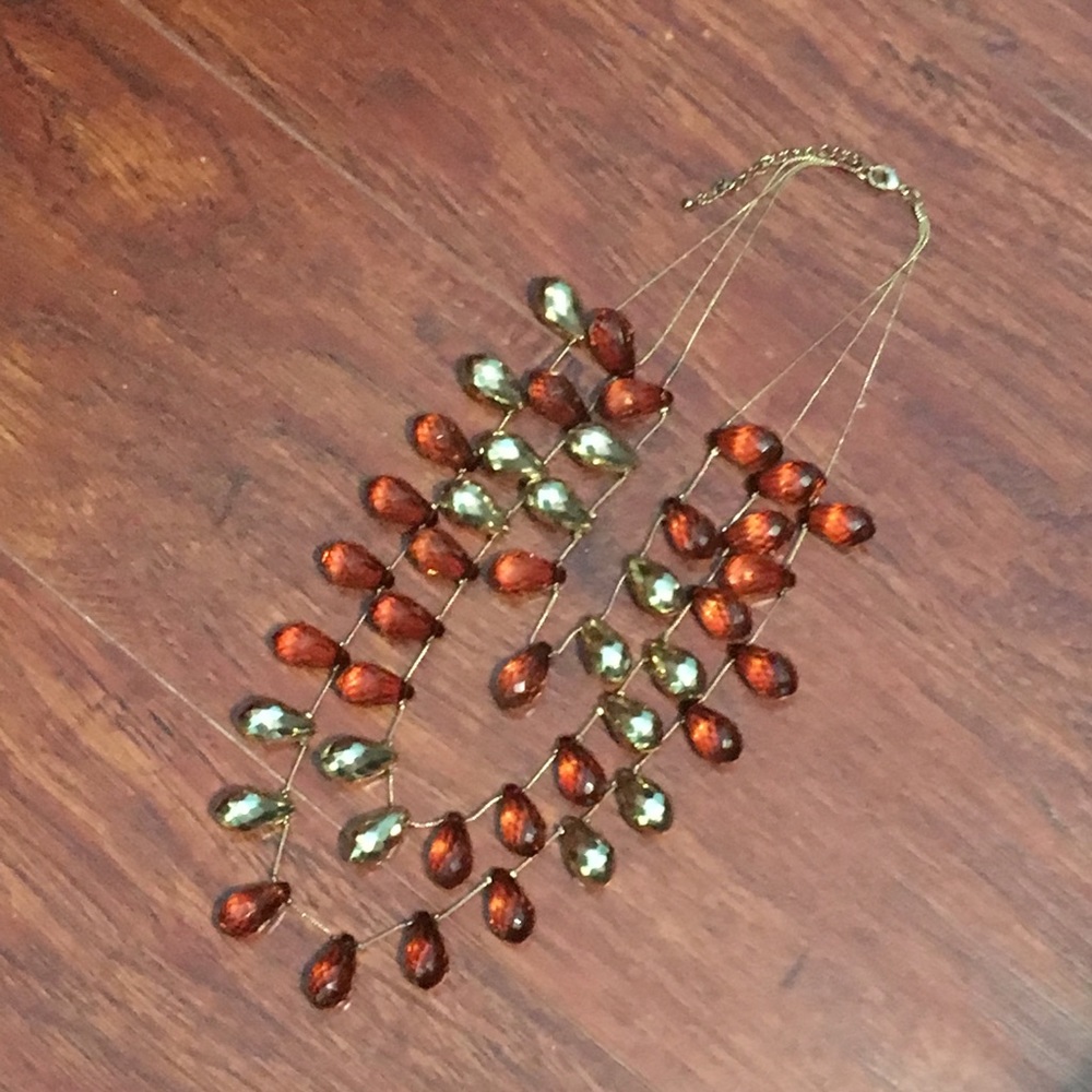 Three chain gold necklace and amber colored gems.